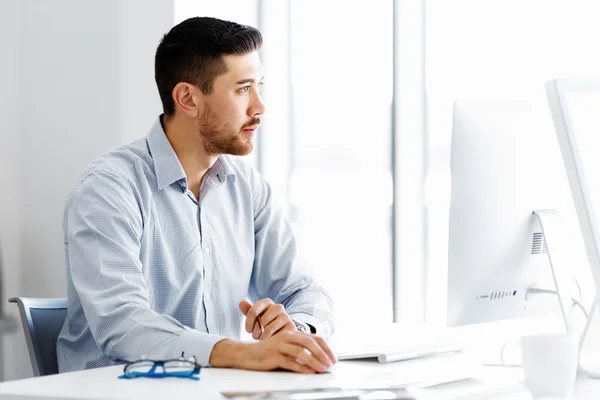 Männliche Büroangestellte sitzt am Schreibtisch — Stockfoto