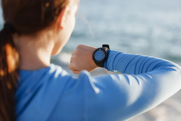 Loper vrouw met hartslagmeter uitgevoerd op strand — Stockfoto