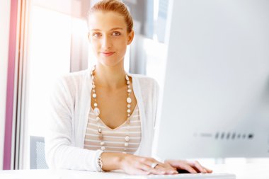 Çekici ofis çalışanı masada oturuyor.