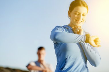 Kalp atış hızı monitörünü plajda çalışan kadınla Runner