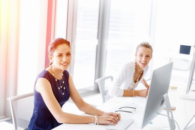 Çekici ofis çalışanı masada oturuyor.