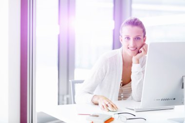 Çekici ofis çalışanı masada oturuyor.