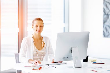 Çekici ofis çalışanı masada oturuyor.