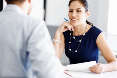 Çekici ofis çalışanı masada oturuyor.