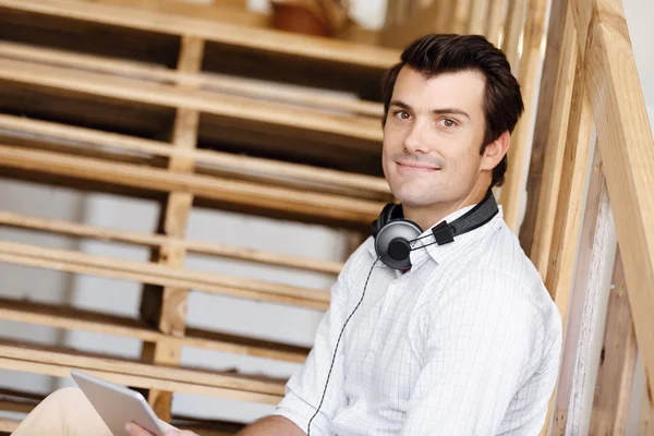 Portrait of young man sitting at the stairs in office — Stock Photo, Image