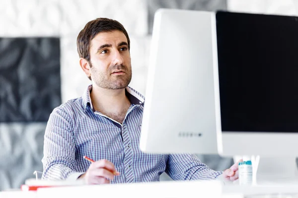 Männliche Büroangestellte sitzt am Schreibtisch — Stockfoto