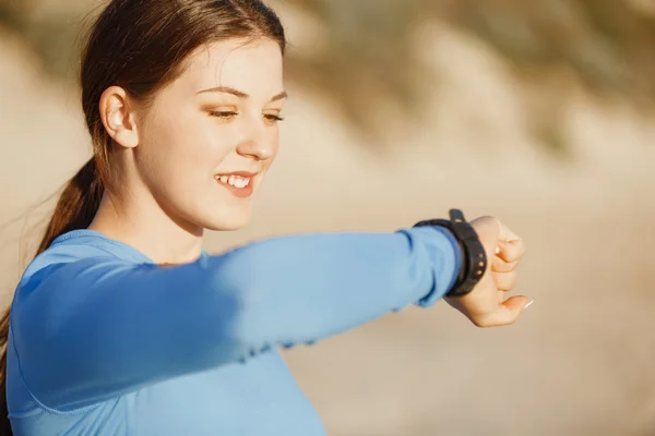 Loper vrouw met hartslagmeter uitgevoerd op strand — Stockfoto