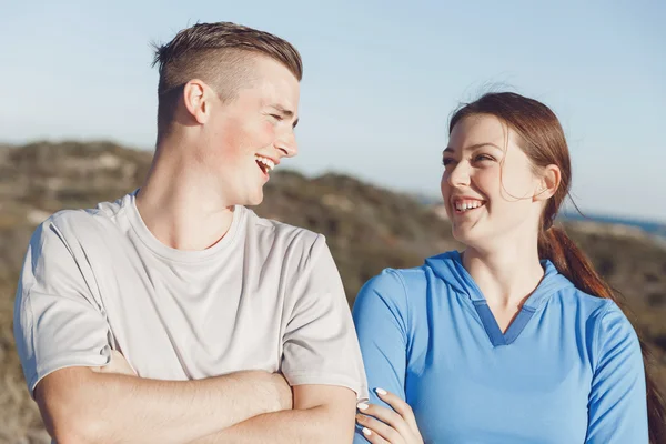 Pareja joven en la playa en ropa deportiva —  Fotos de Stock