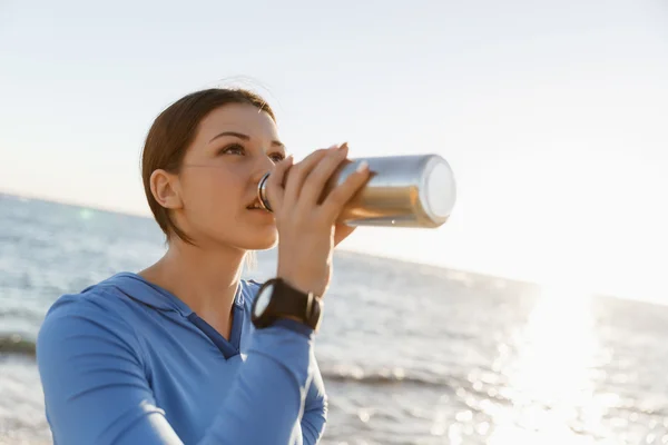 ビーチで水を飲む女性 — ストック写真