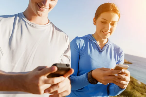 Jeune couple avec smartphones en plein air — Photo