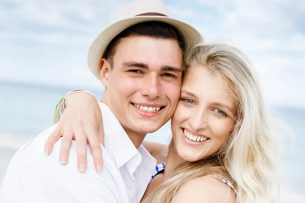 Romántica pareja joven sentada en la playa — Foto de Stock