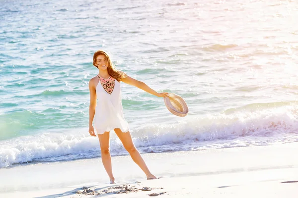 Junge Frau läuft am Strand entlang — Stockfoto