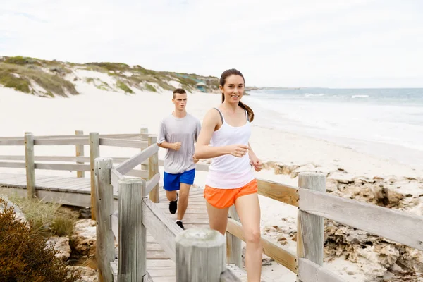 Runners. Young couple running on beach — Stock Photo, Image