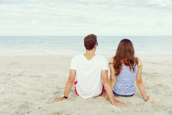 Romántica pareja joven sentada en la playa —  Fotos de Stock