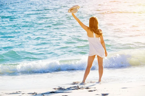 Junge Frau läuft am Strand entlang — Stockfoto