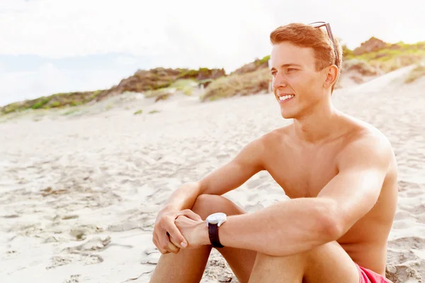 Knappe man die zich voordeed op strand — Stockfoto