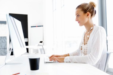 Çekici ofis çalışanı masada oturuyor.