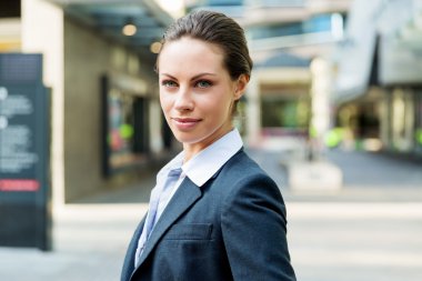 Açık havada gülümseyen bir iş kadını portresi.