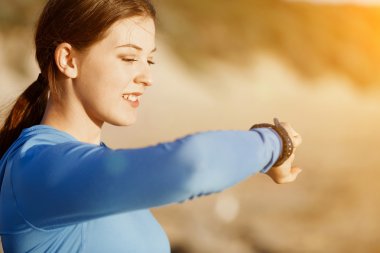 Kalp atış hızı monitörünü plajda çalışan kadınla Runner