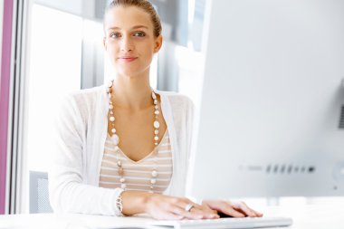 Çekici ofis çalışanı masada oturuyor.