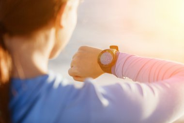 Kalp atış hızı monitörünü plajda çalışan kadınla Runner