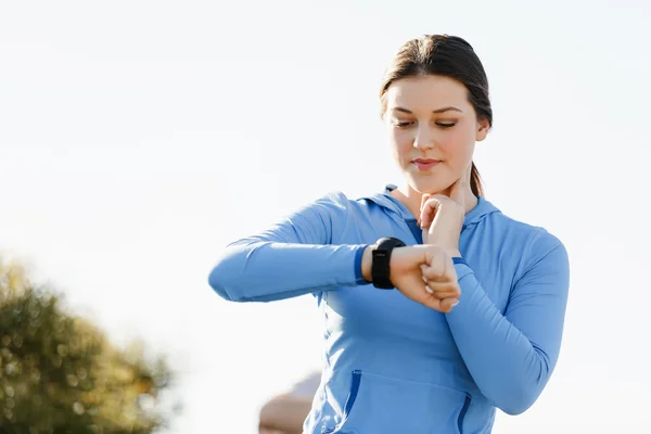 Runner donna con cardiofrequenzimetro in esecuzione sulla spiaggia — Foto Stock