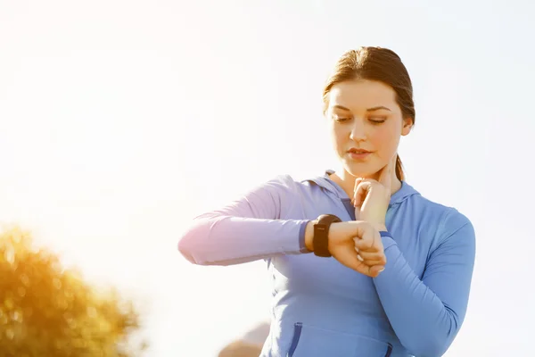 Mujer corredora con monitor de frecuencia cardíaca corriendo en la playa — Foto de Stock
