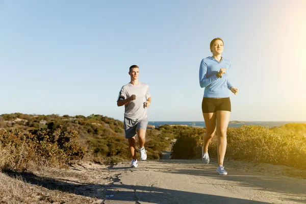 Sport runner joggen op strand uit te werken met haar partner — Stockfoto