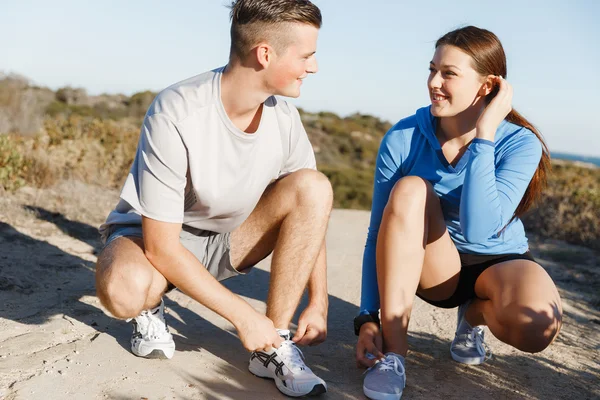 Casal de corredores rendem seus sapatos e se preparam para correr — Fotografia de Stock