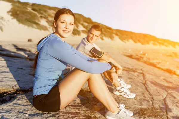Paar in sport dragen op strand — Stockfoto