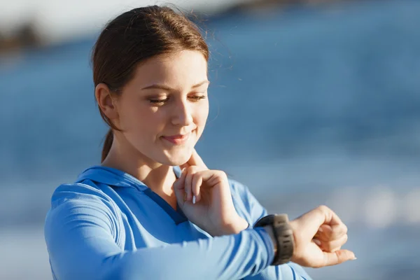 Runner femme avec moniteur de fréquence cardiaque en cours d'exécution sur la plage — Photo