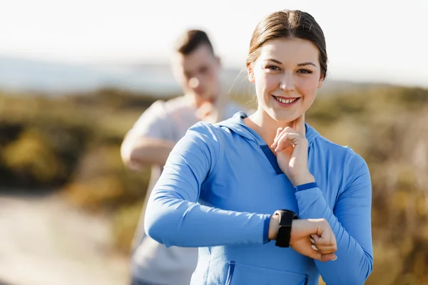 Runner donna con cardiofrequenzimetro in esecuzione sulla spiaggia — Foto Stock