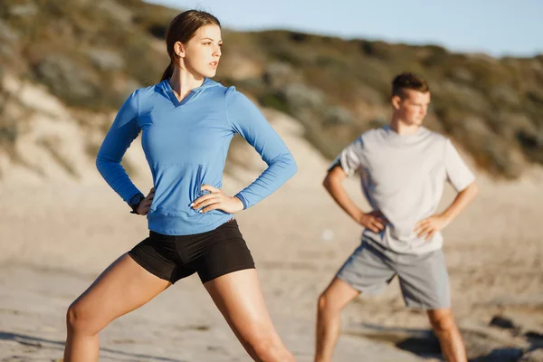 Jeune couple sur la plage d'entraînement ensemble — Photo