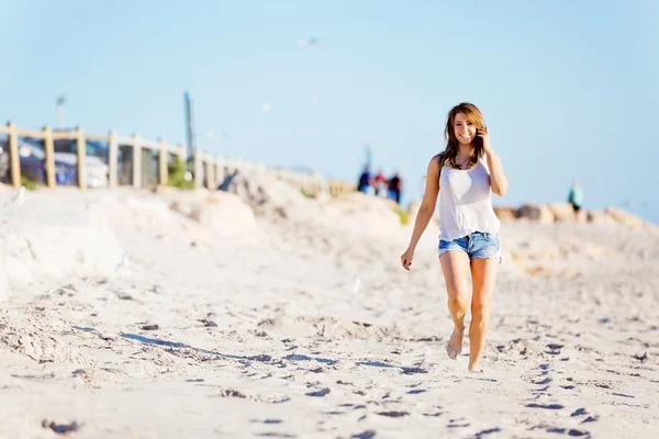 Jeune femme marchant le long de la plage — Photo