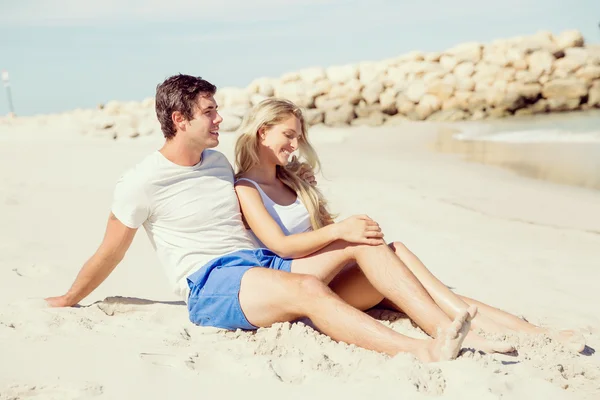 Romantico giovane coppia seduta sulla spiaggia — Foto Stock