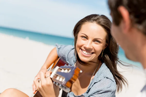 Güzel genç bir kadın sahilde gitar çalıyor. — Stok fotoğraf