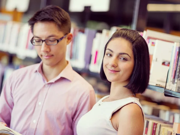 Group of young students at the library — Stock Photo, Image