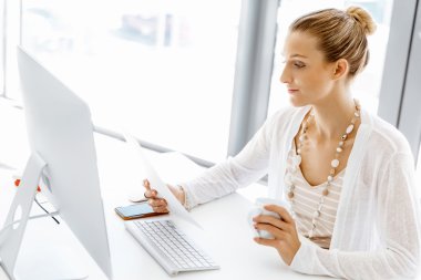 Çekici ofis çalışanı masada oturuyor.