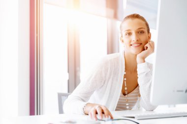 Çekici ofis çalışanı masada oturuyor.