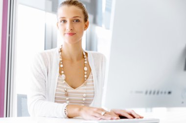 Çekici ofis çalışanı masada oturuyor.