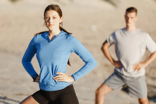 Jeune couple sur la plage d'entraînement ensemble — Photo