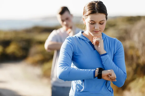 Loper vrouw met hartslagmeter uitgevoerd op strand — Stockfoto