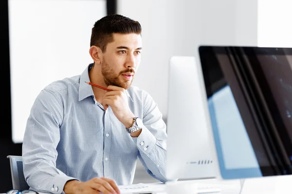 Männliche Büroangestellte sitzt am Schreibtisch — Stockfoto