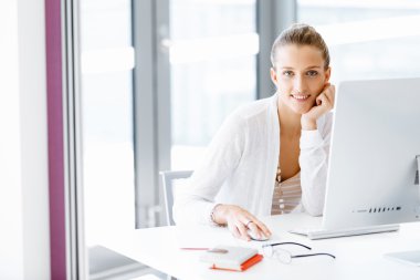 Çekici ofis çalışanı masada oturuyor.