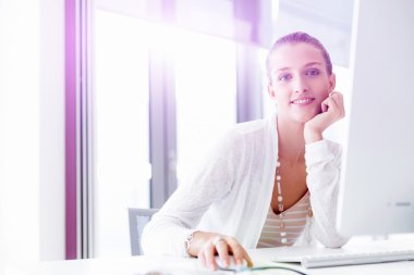 Çekici ofis çalışanı masada oturuyor.