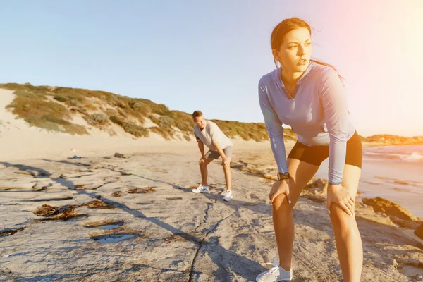 Junges Paar trainiert gemeinsam am Strand — Stockfoto