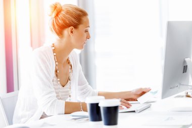 Çekici ofis çalışanı masada oturuyor.