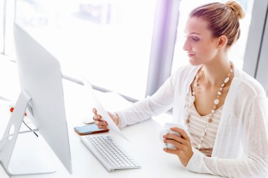 Çekici ofis çalışanı masada oturuyor.