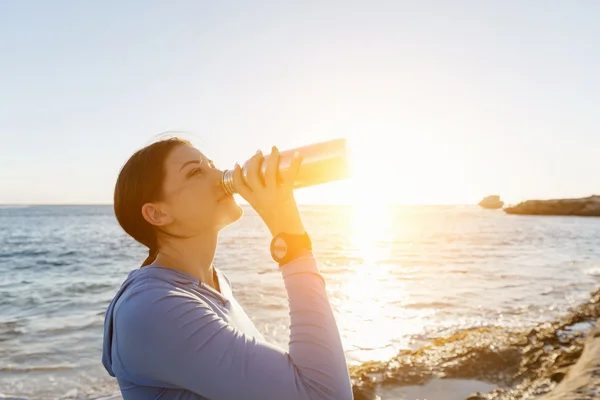 ビーチで水を飲む女性 — ストック写真