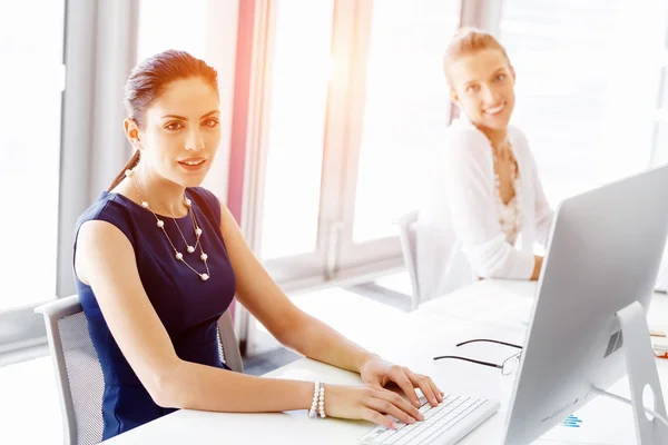 Attractive office worker sitting at desk — Stock Photo, Image